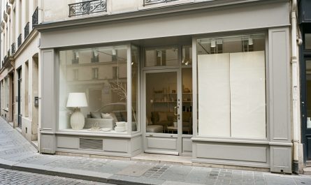Devanture sobre d’un magasin de décoration fermé dans une rue commerçante française, avec vitrines peu garnies et ambiance réaliste et documentaire.